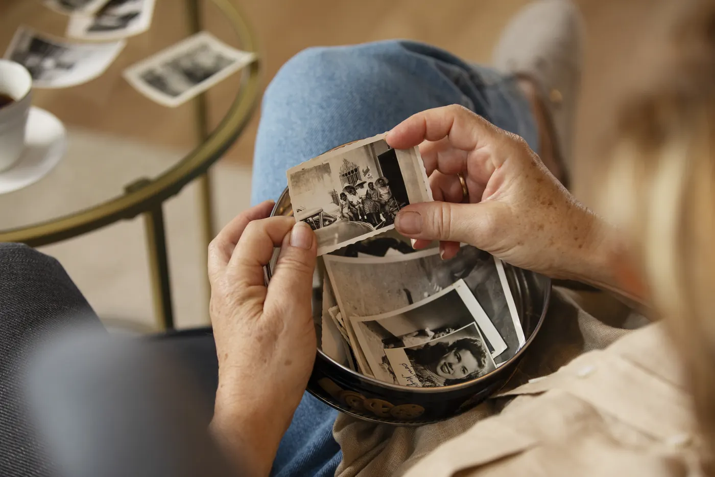 Mãos segurando fotografias antigas da família.